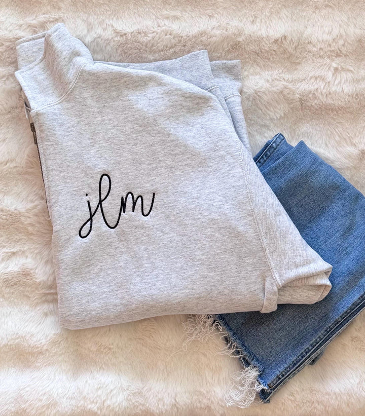 a custom embroidered monogrammed quarter-zip pullover sweatshirt featuring three embroidered initials on the chest.