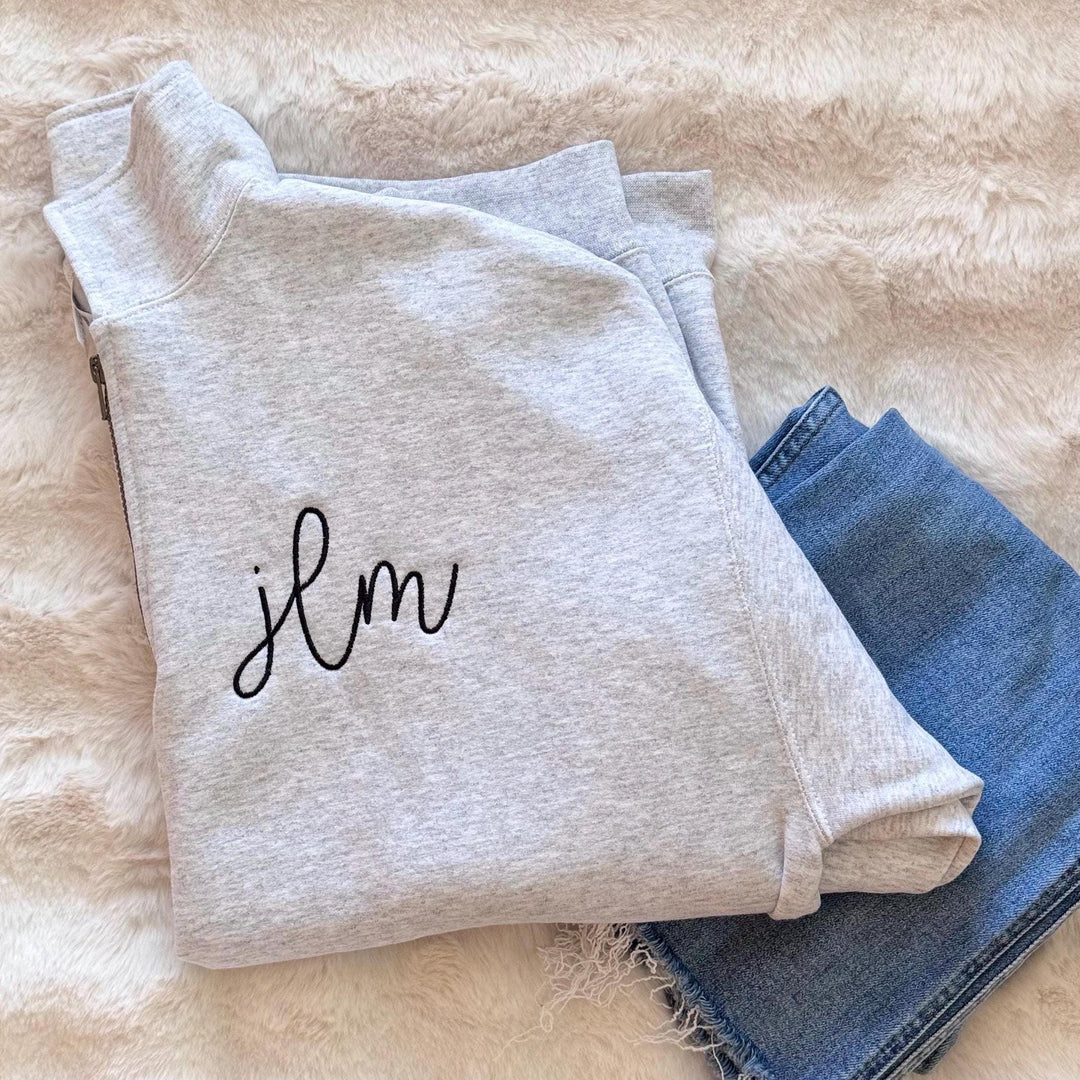 a custom embroidered monogrammed quarter-zip pullover sweatshirt featuring three embroidered initials on the chest.